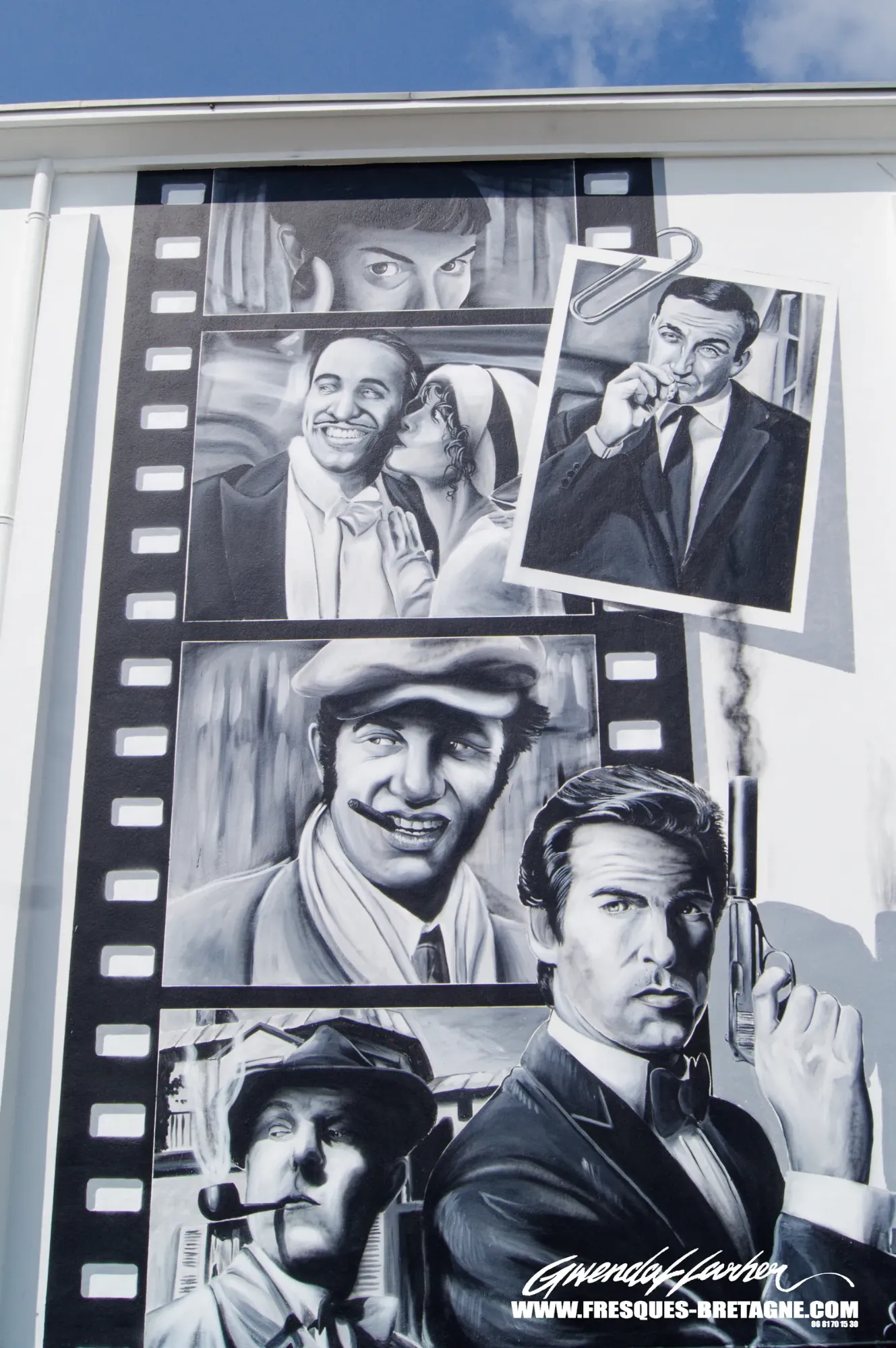 Street art noir et blanc, détail de la façade du cinéma Le Dauphin à Plouescat : portraits d'acteurs dans une bande de pellicule peints sur le mur, fresque murale d'un artiste graffeur